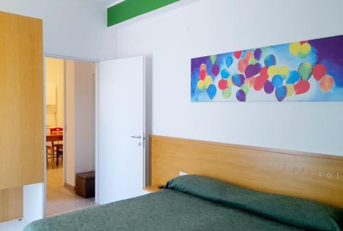 ヴィッラピアーナにあるIl Piccolo Principe Relaisのベッドルーム1室(ベッド1台付)が備わります。壁には絵画が飾られています。