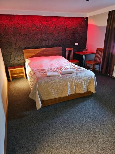 a bedroom with a bed and a red wall at "Zacisze" in Zgierz
