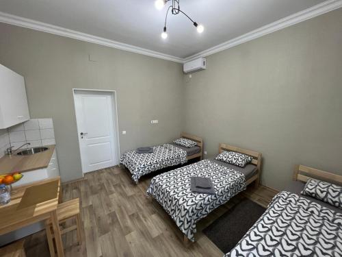 een kamer met 2 bedden, een tafel en een keuken bij Гостевой Отель-125 in Aqtau