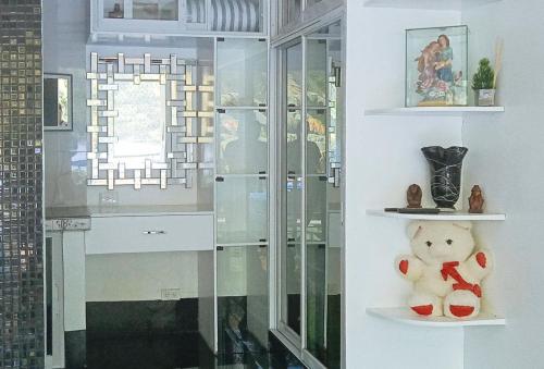 a teddy bear sitting on a shelf in a room at KrizLion Hotel in Hinatuan