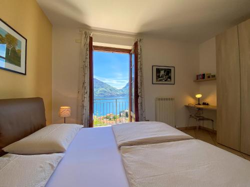 a bedroom with two beds and a large window at Torre Ferienwohnung mit Garten in San Siro