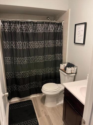 a bathroom with a toilet and a shower curtain at 2Bdrm Comfortable Townhome 5 Mins from Airport in Atlanta