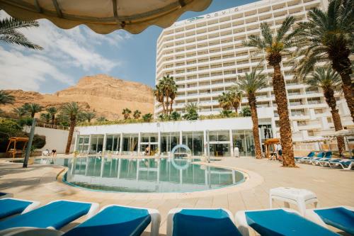 un hotel con piscina y palmeras en David Dead Sea Resort & Spa en Ein Bokek