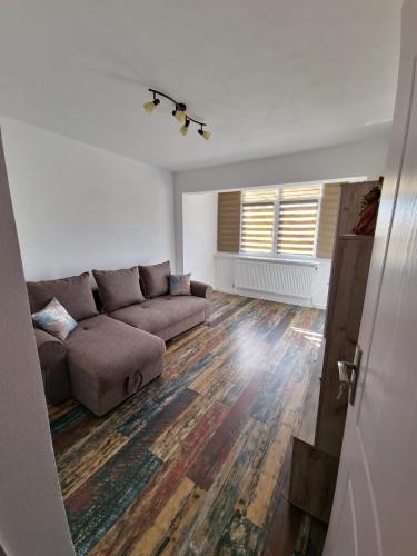 a living room with a couch and a window at APARTAMENT 2 CAMERE in Bechet