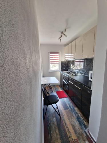 a kitchen with a table and a chair in a room at APARTAMENT 2 CAMERE in Bechet