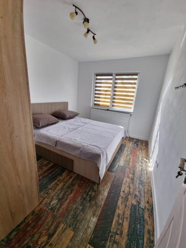a bedroom with a bed and a window at APARTAMENT 2 CAMERE in Bechet