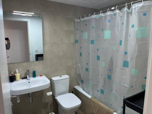 a bathroom with a toilet and a sink and a mirror at Magnífico apartamento nuevo en 1ª línea de playa in Mojácar