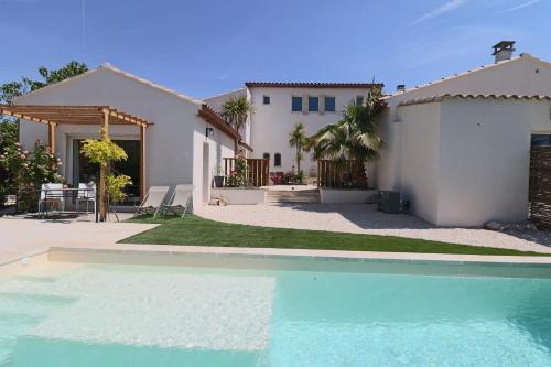 une maison avec une piscine devant une maison dans l'établissement Le mas Sainte Marie, à Venasque