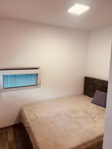 a small bedroom with a bed and a window at Residence 7 in Štúrovo