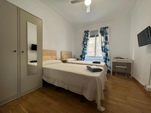 - une chambre avec 2 lits et une fenêtre dans l'établissement Dos Torres Lacarra - Espacioso con 7 Camas Individuales, à Saragosse