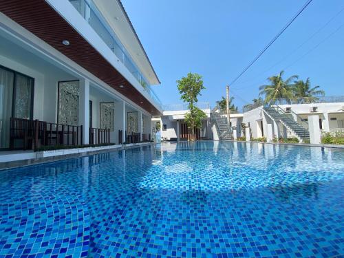 una piscina en un complejo con azulejos azules en West Life Bungalow Phu Quoc en Phu Quoc