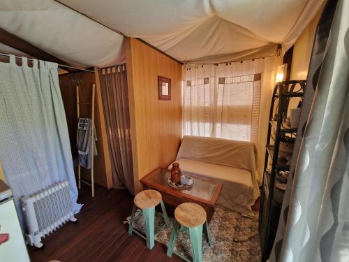 Cette petite chambre comprend un lit et deux tabourets. dans l'établissement Lodge de Charme 2 Chambres, à Ghisoni