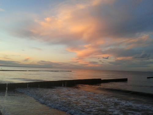 una playa con un cielo nublado y el océano en Landhaus Krummin, en Krummin