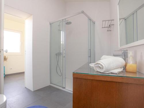 ein Badezimmer mit Glasdusche und Waschbecken in der Unterkunft Casa do Poeta in Figueira da Foz