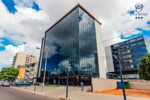 a tall glass building on a city street at OTIA HOTEL in Maputo