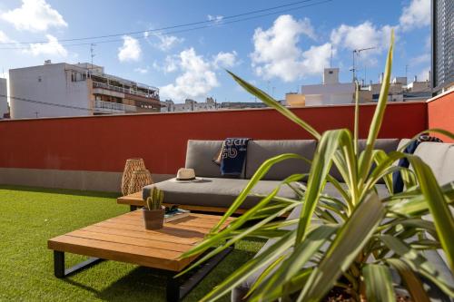 a couch on a rooftop with a table and plants at Alidreams Lola Center Apartamentos in Alicante