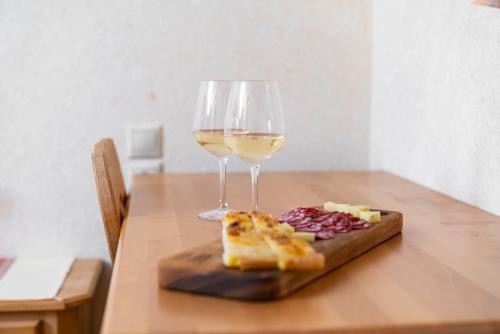 a glass of wine and a plate of bread and cheese at Guesthouse Močivnik in Okroglice