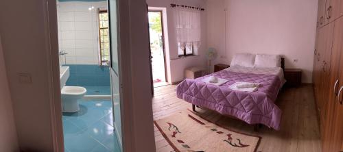 Habitación con cama y baño con bañera. en Guest House Bakuli, en Gjirokastra