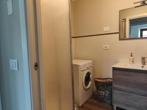 a bathroom with a washing machine and a sink at Suite a Folgaria in Folgaria
