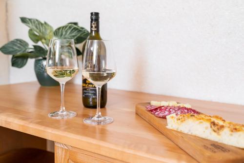 a table with two glasses of wine and a slice of pizza at Guesthouse Močivnik in Okroglice
