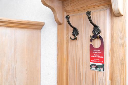 a wooden door with a sign hanging on it at Guesthouse Močivnik in Okroglice