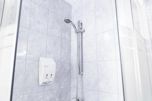 a shower with a shower head in a bathroom at Guesthouse Močivnik in Okroglice