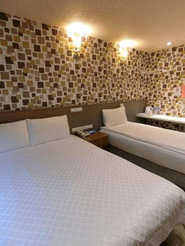 a hotel room with two beds and lights on the wall at Taiwan Seven Days Boutique Hotel in Taipei