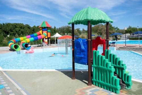 een zwembad met een waterpark met een waterglijbaan bij Camping Atlanta & Mediterraneo Family Village in Sottomarina