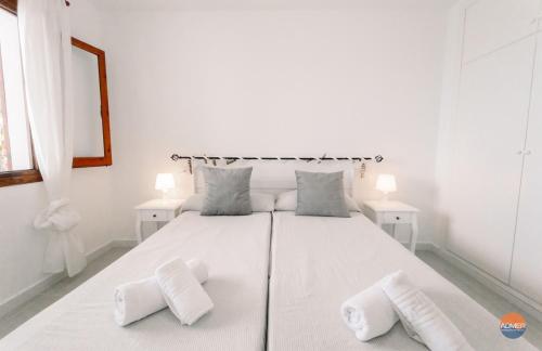 een witte slaapkamer met een groot wit bed met 2 kussens bij Aldeas Taray Admer 002 in La Manga del Mar Menor