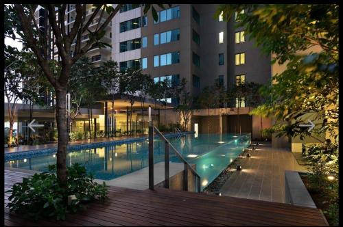 a swimming pool in front of a tall building at Mercu Summer Suite KLCC Studio with Karaoke in Kuala Lumpur