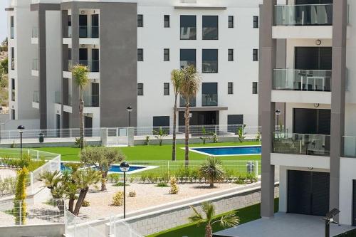 アリカンテにあるVillamartin Spacious Modern flat -3 pools jacuzzi tennis golfのヤシの木が茂るアパートメントビル