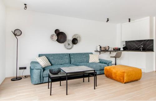 a living room with a blue couch and a table at Résidence Palace Expo in Brussels