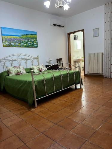 a bedroom with a green bed in a room at Le Stanze di Lucia vicino Ospedale Cardinale Panico a Tricase in Tricase