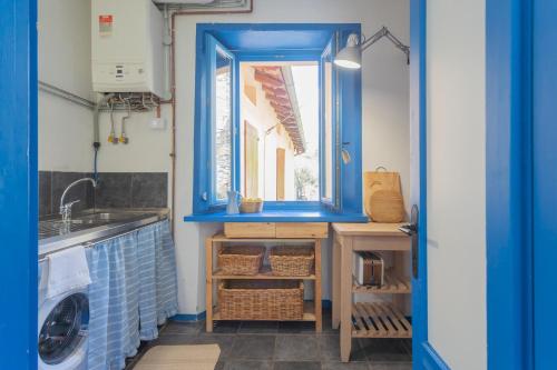 une cuisine bleue avec un évier et une fenêtre dans l'établissement Deriva Apartment on Careno's Beach by Rent All Como, à Nesso