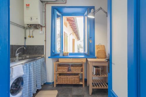 a blue kitchen with a sink and a window at Deriva Apartment on Careno's Beach by Rent All Como in Nesso