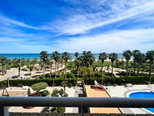 Blick auf ein Resort mit Pool und Palmen in der Unterkunft Dorado Amanecer frente al Mar in Oropesa del Mar