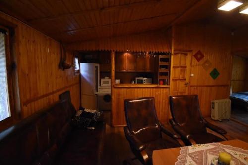 a kitchen with a table and chairs and a refrigerator at Domek u Justy. in Przyjezierze