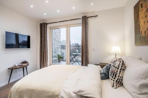 um quarto branco com uma cama grande e uma janela em Charming Apartment Close to Heart of Hamburg em Hamburgo