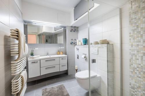 ein weißes Bad mit einem WC und einem Waschbecken in der Unterkunft Charming Apartment Close to Heart of Hamburg in Hamburg