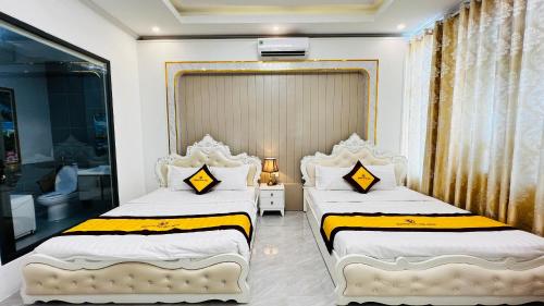 a bedroom with two beds with yellow and white sheets at Khach sạn Starfish Tuy Hoà in Tuy Hoa