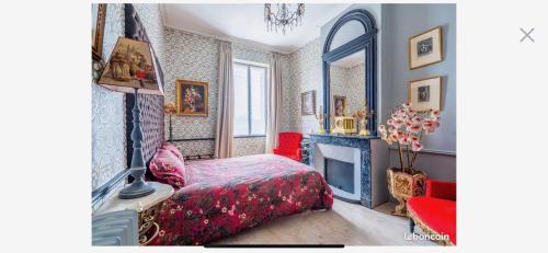 1 dormitorio con cama, chimenea y espejo en La Maison Blanche à Saint-Yzans-de-Médoc, en Saint-Yzans-de-Médoc