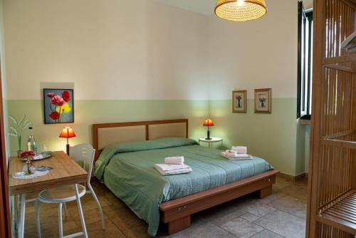 a bedroom with a bed and a table and a desk at Agriturismo Il Sorriso Degli Ulivi - Dimora di Charme in Gallipoli