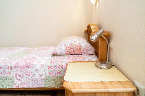 a small bedroom with a bed and a lamp on a table at Guesthouse Močivnik in Okroglice