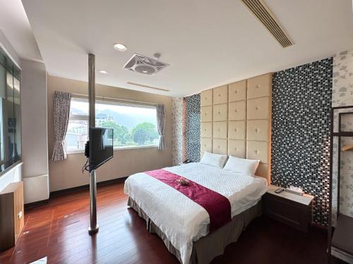 1 dormitorio con 1 cama y TV. en Li Quan Hot Spring Resort, en Baihe