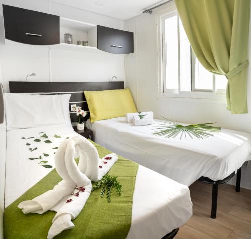 a hotel room with two beds with towels on them at Camping Atlanta & Mediterraneo Family Village in Sottomarina