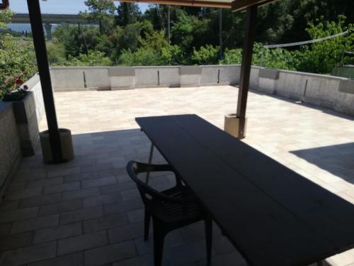 - une table et une chaise sous un parasol sur la terrasse dans l'établissement Confortevole locale, à Rosignano Marittimo