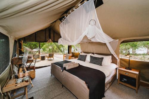 a bedroom with a bed in a tent at Tsowa Safari Island in Victoria Falls