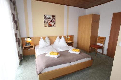 a bedroom with a bed with two towels on it at Hotel & Frühstückspension Raabtal in Feldbach