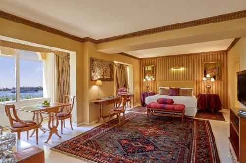 um quarto de hotel com uma cama, uma mesa e cadeiras em Steigenberger Resort Achti em Luxor