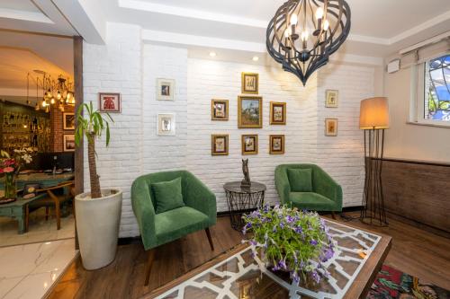 a living room with two green chairs and a table at The Marions Suite istanbul Special Category Taksim in Istanbul